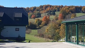 Un bâtiment doté d’un toit végétalisé et d’une façade blanche, entouré d’une pelouse et d’arbres aux feuilles d’automne.