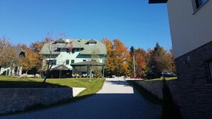Un chemin menant à un bâtiment doté d’un toit végétalisé et d’une zone abritée.