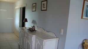 A hallway with a white console table, a lamp, and framed pictures on the wall. - Beautiful newly built house with private pool in the Ardèche (Chassagnes)