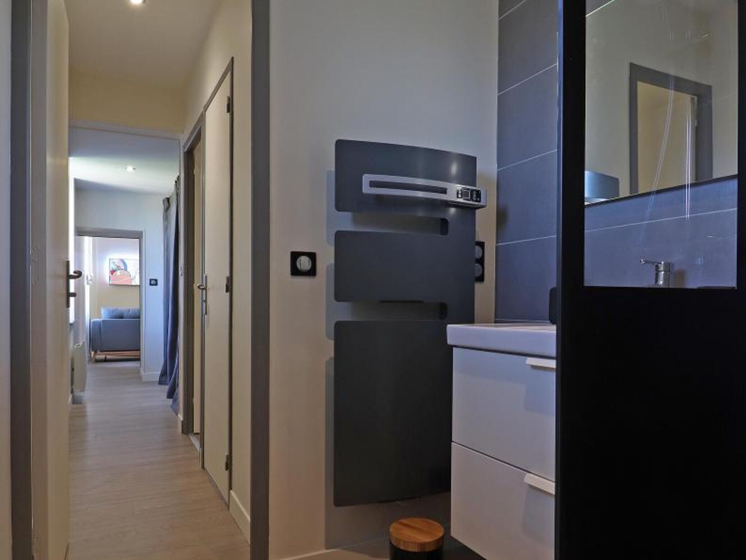 Een moderne badkamer met een grote spiegel, een wastafel en een klein toilet.