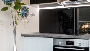 Una cocina moderna con microondas, horno y campana extractora Bosch.