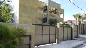 Un immeuble résidentiel doté d’une façade en béton, d’une entrée sécurisée et d’un escalier menant à un étage supérieur.