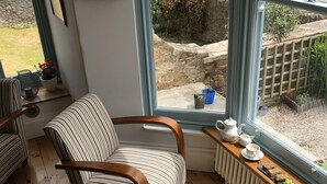 A cozy corner with striped chairs, a view of a marina, and a small table with a teapot and cups. - Beacon House (Brixham)