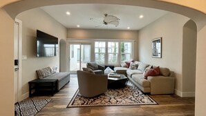 A spacious living room with a sofa, armchairs, and a coffee table. - Gorgeous Designer Oasis in Pacific Beach, central AC, wifi, and parking! (San Diego)