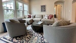 A modern living room with a sectional sofa, two armchairs, a coffee table, and a patterned rug. - Gorgeous Designer Oasis in Pacific Beach, central AC, wifi, and parking! (San Diego)