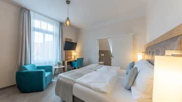 Een hotelkamer met een bed, een bureau, een stoel en een bank.