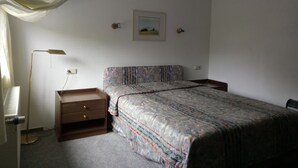 A bedroom with a bed, a nightstand, a lamp, and a painting on the wall. - Hotel Leppiner Hof (Arendsee)