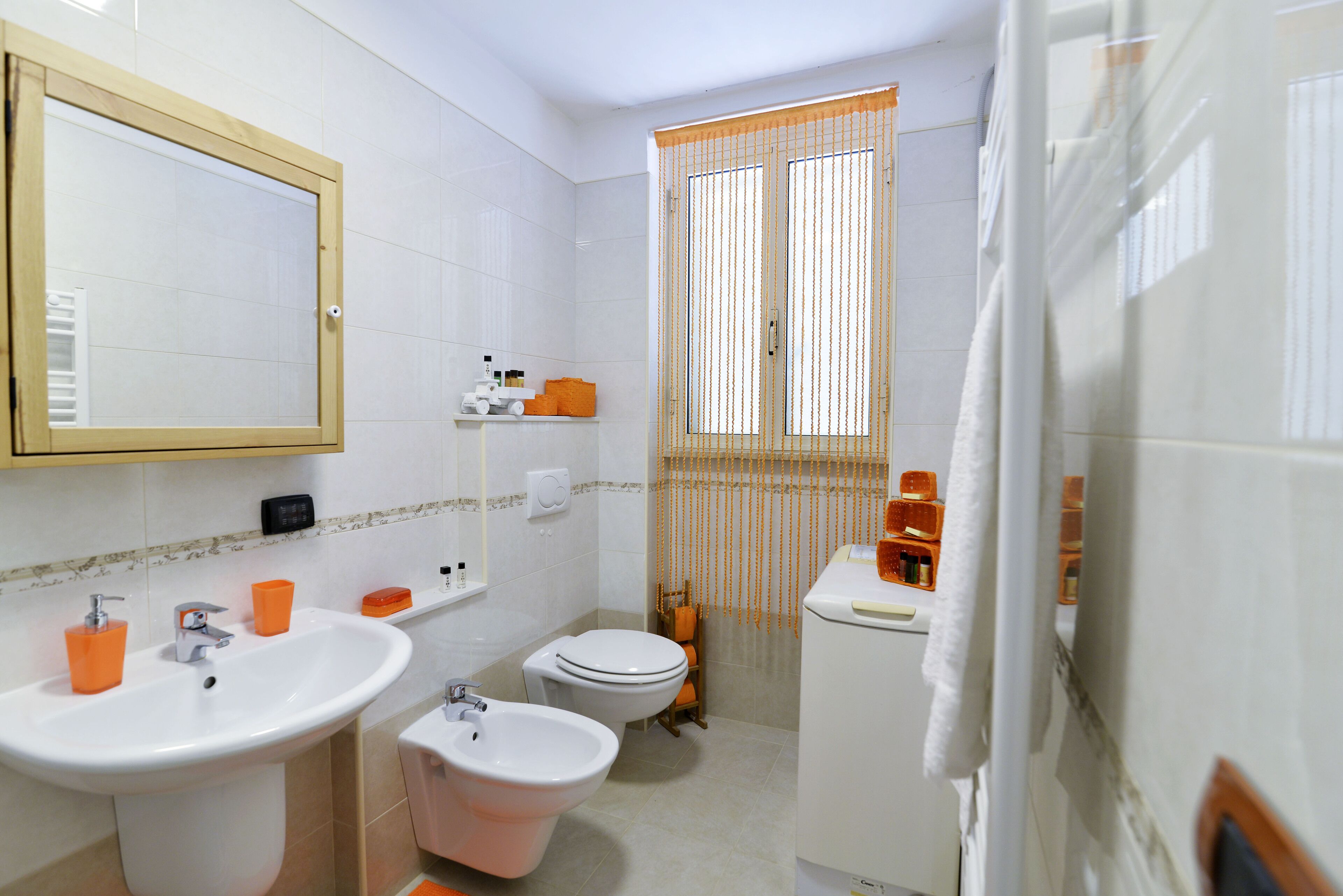 A bathroom with a sink, bidet, toilet, and a mirror.