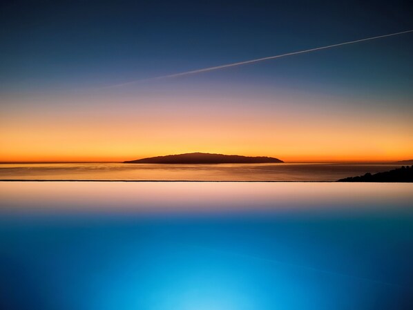 Eine Küstenlandschaft mit klarem Horizont und einer fernen Insel.'