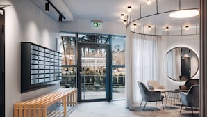 A modern lobby with a bench, seating area, and a large window. - Jurmala Park House (Jurmala)