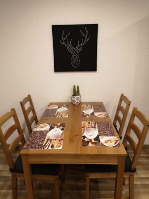 Enjoy meals in this cozy dining area with a wooden table, comfortable chairs, and a unique deer head artwork above.