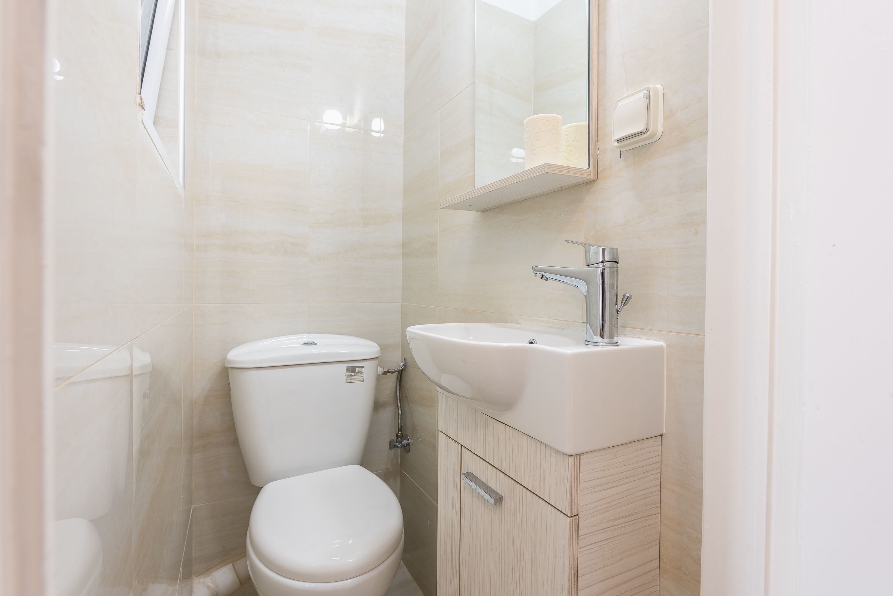 A modern bathroom with a toilet, sink, and mirror.