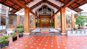 A hotel lobby with a tiled floor, wooden pillars, and a sign reading "THIEN AN". - Thien An Hotel (Can Tho)