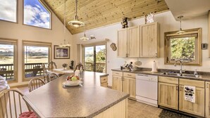 A spacious kitchen with granite countertops, wooden cabinets, and large windows offering scenic views. - Quiet Fairplay Cabin w/ Rocky Mountain Views! (Fairplay)