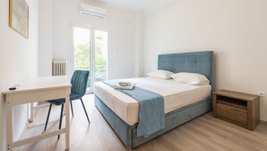 Una camera da letto con un letto, una scrivania, una sedia e un termosifone.
