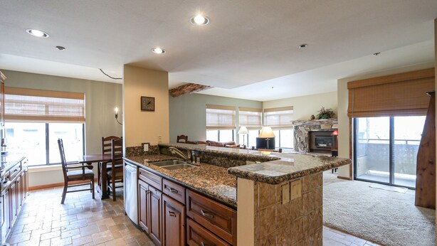 A spacious kitchen with granite countertops, wooden cabinets, and a large island.