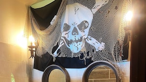 A bathroom with two sinks, a mirror, and a skull decoration on the wall. - Auberge K-Wan Hostel (Deshaies)