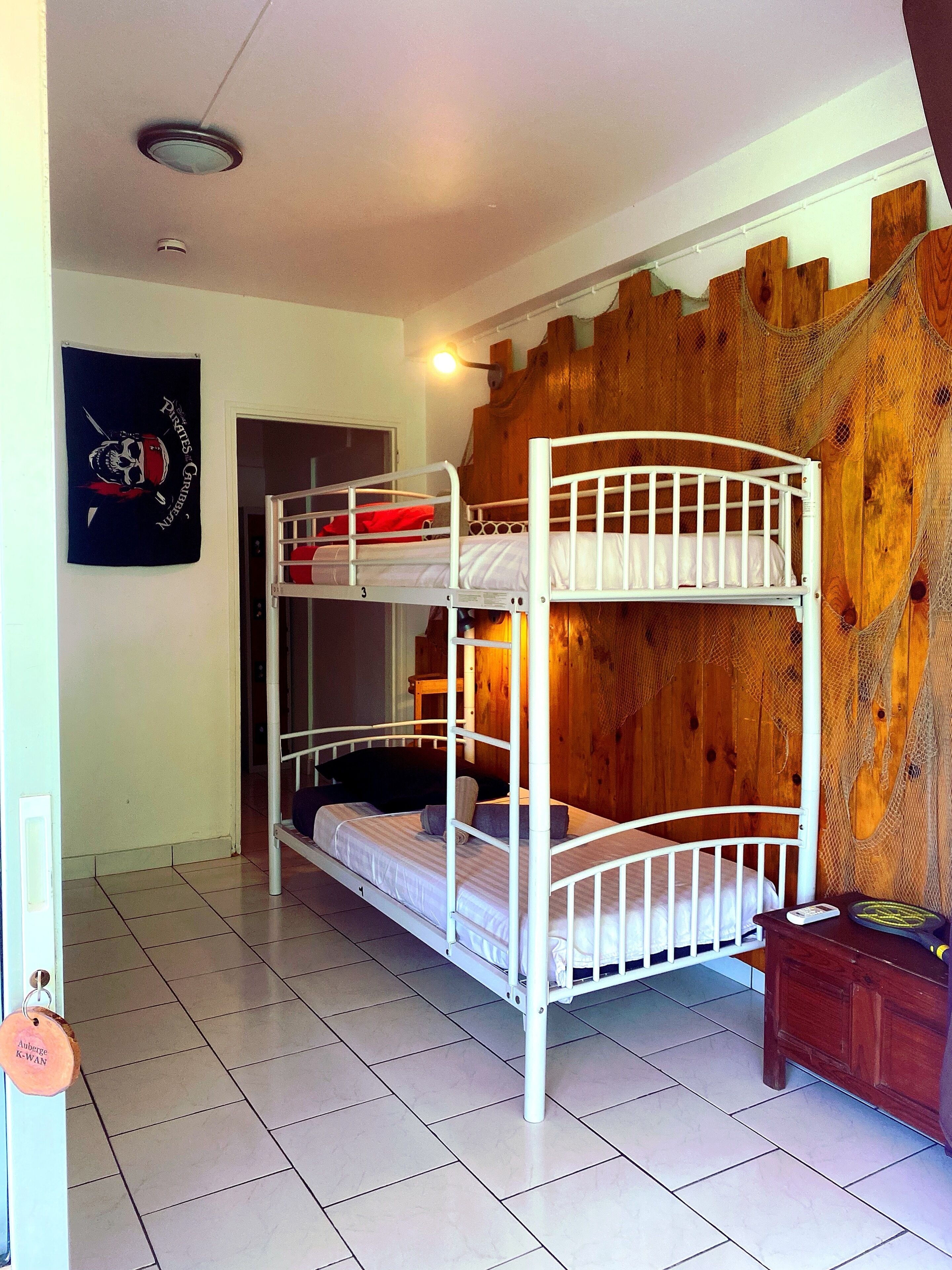 A bunk bed room with a wooden wall and a poster on the wall.