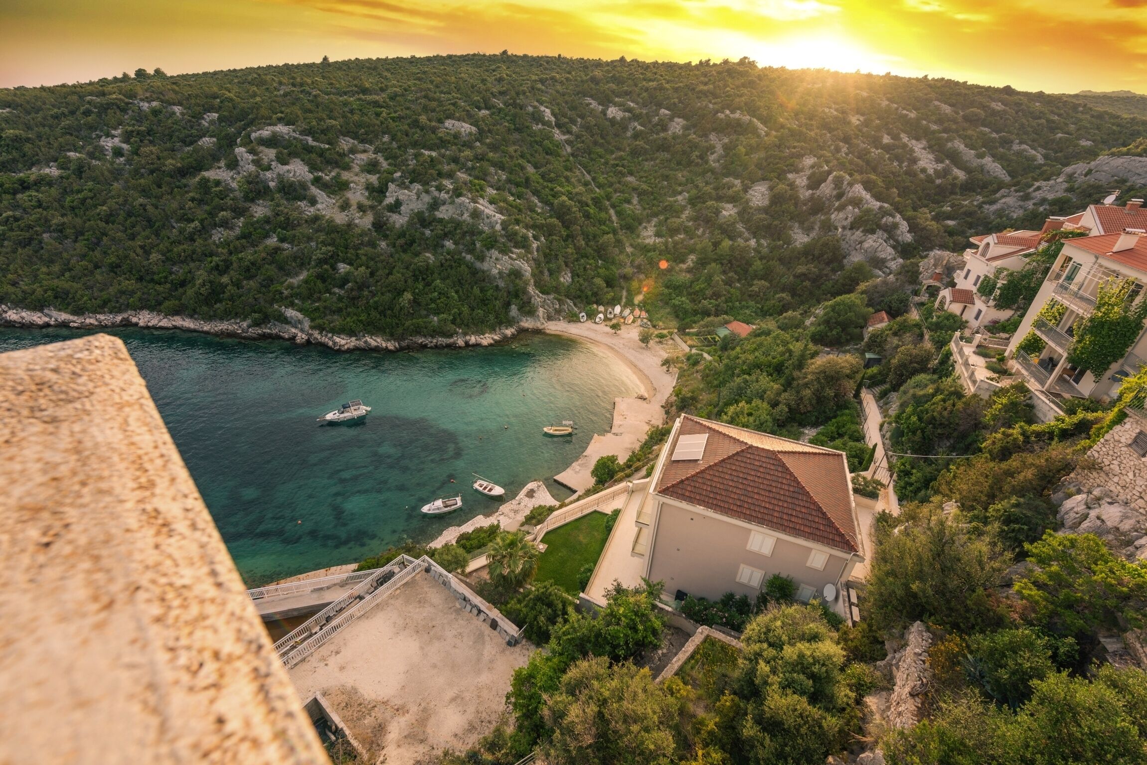 A coastal village with a beach, boats, and traditional houses.