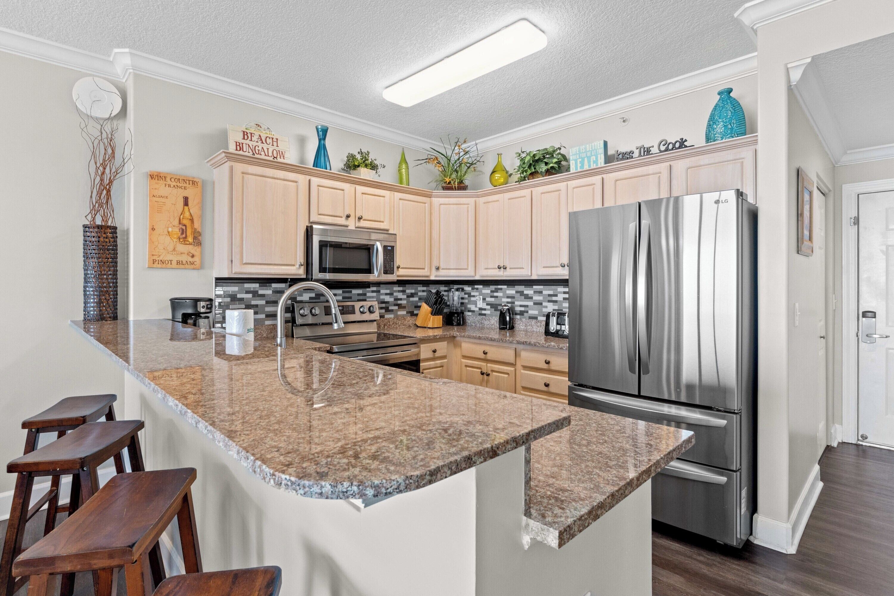 A modern kitchen with granite countertops, stainless steel appliances, and wooden cabinets.