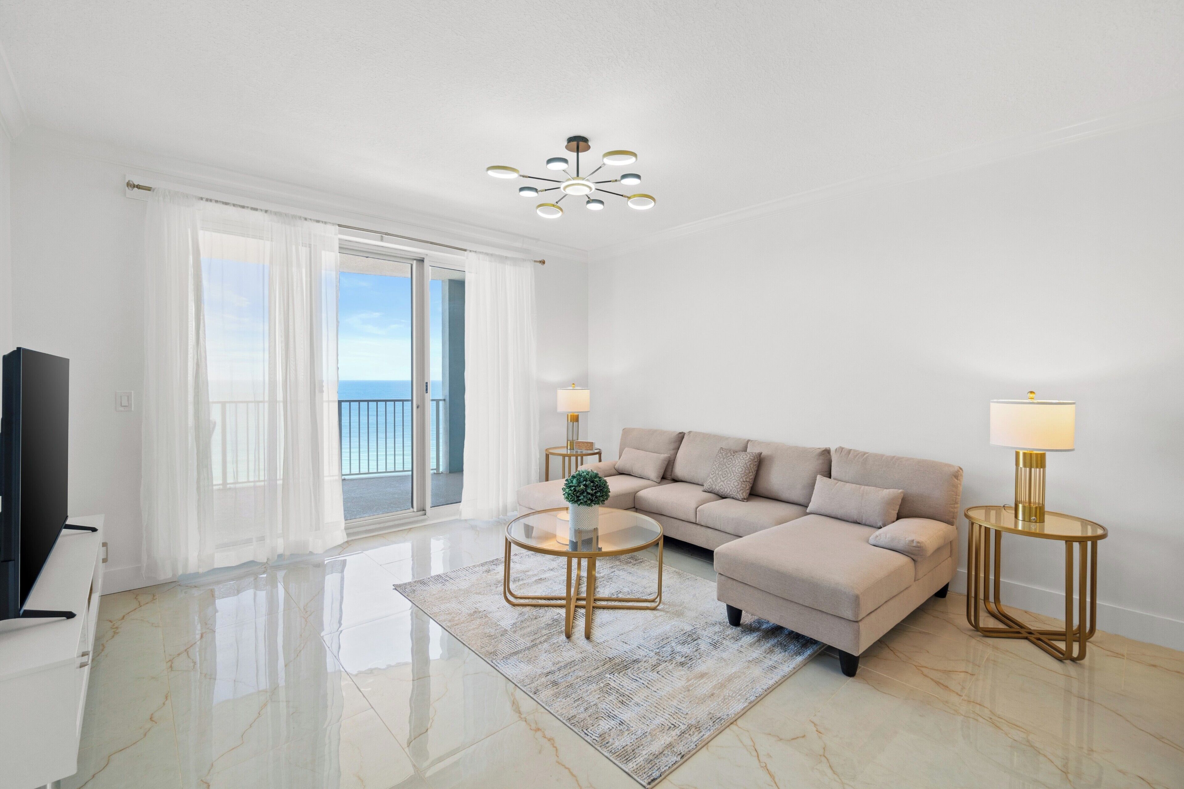 A modern living room with a sofa, two side tables, a coffee table, and a TV.