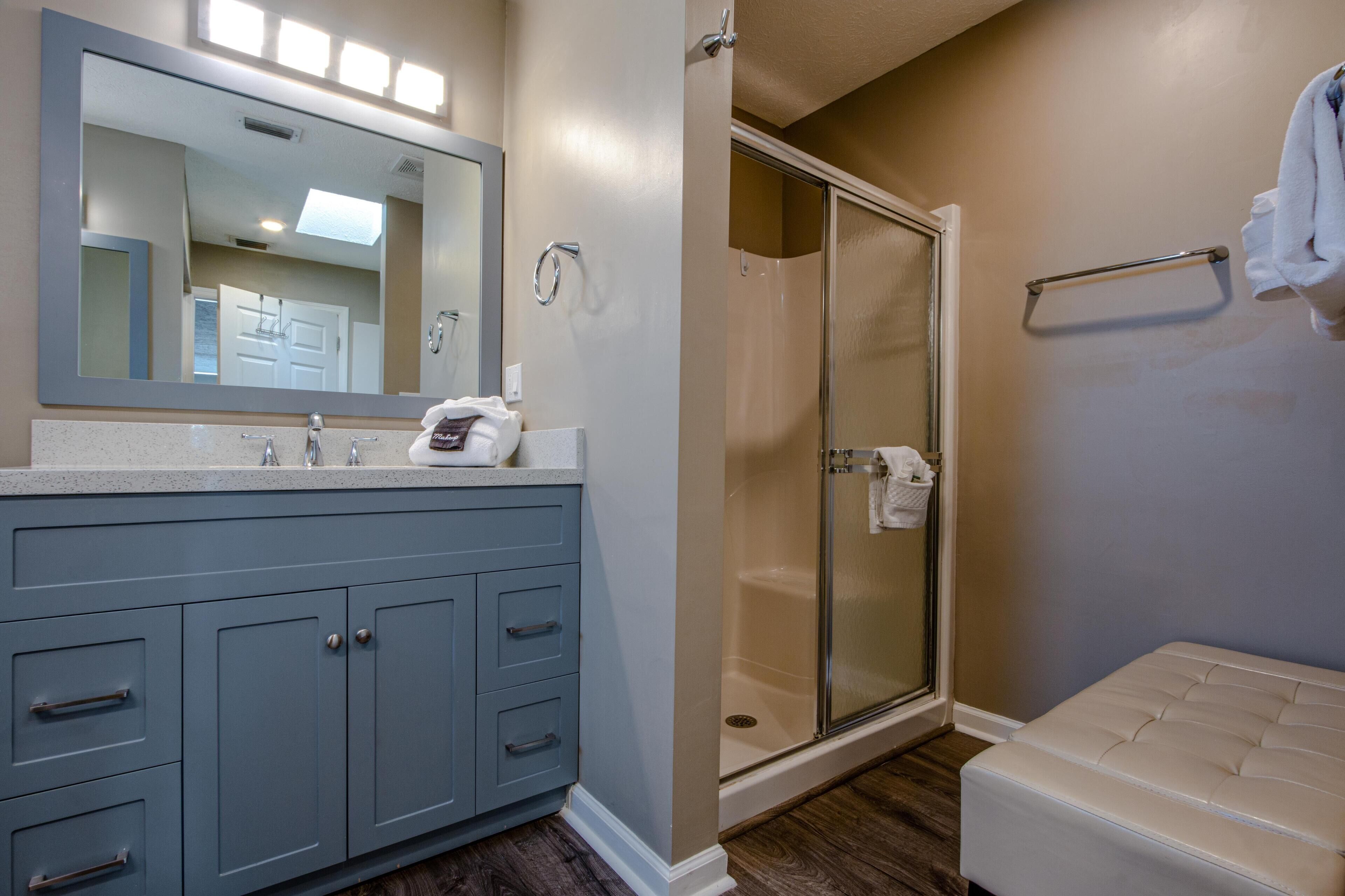 A bathroom with a vanity, a shower, and a toilet.