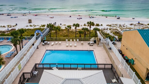 Ein Poolbereich mit Blick auf Strand und Meer.