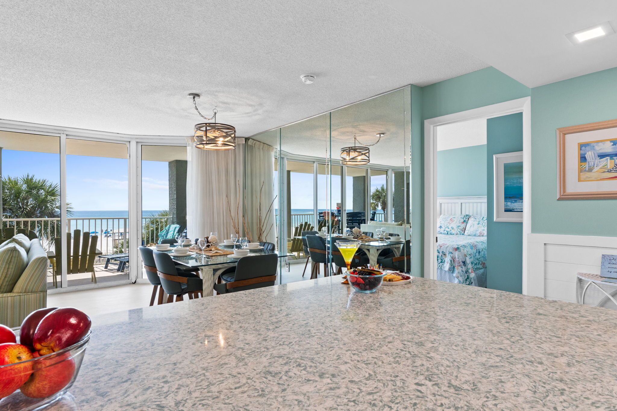 Una cocina moderna con una isla grande, comedor y vista al océano.
