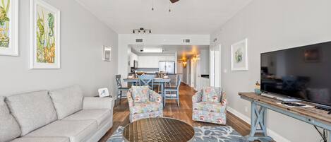 A living room with a sofa, chairs, a coffee table, and a TV.