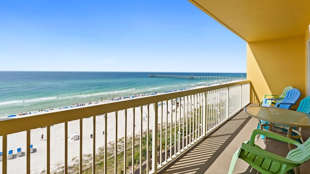 A balcony with a view of the beach and ocean, featuring a table and chairs. - Calypso Resort and Towers by Book That Condo (Panama City Beach)