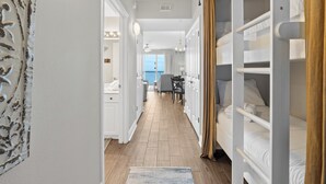A hotel corridor with bunk beds, a dining area, and a view of the outdoors. - Celadon Beach Resort by Book That Condo (Panama City Beach)