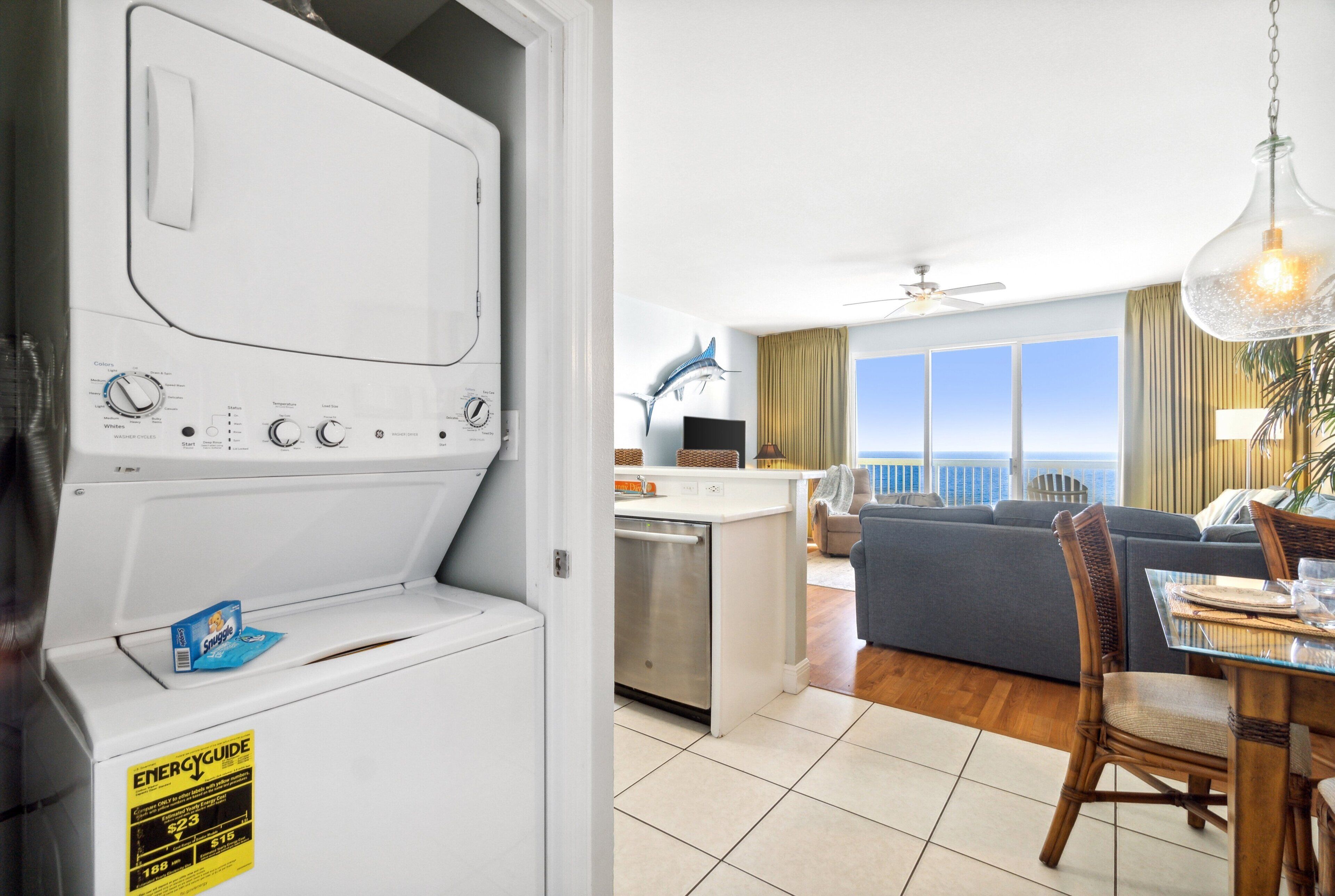 A laundry room with a washing machine and a dining area with a table and chairs.