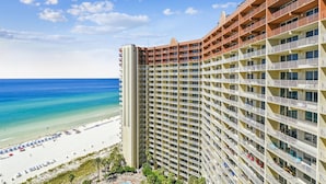 Hotel alto com várias varandas com vista para a praia.