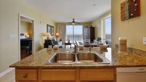 A kitchen with granite countertops, stainless steel sinks, and a built-in dishwasher.