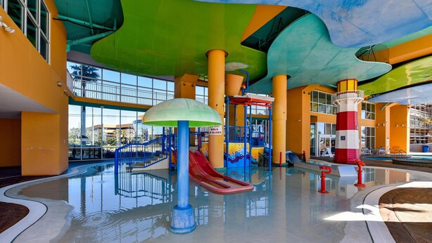 An indoor water park with slides, a play structure, and a pool area.