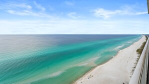 An aerial view of a beach with clear turquoise waters and a sandy shore.