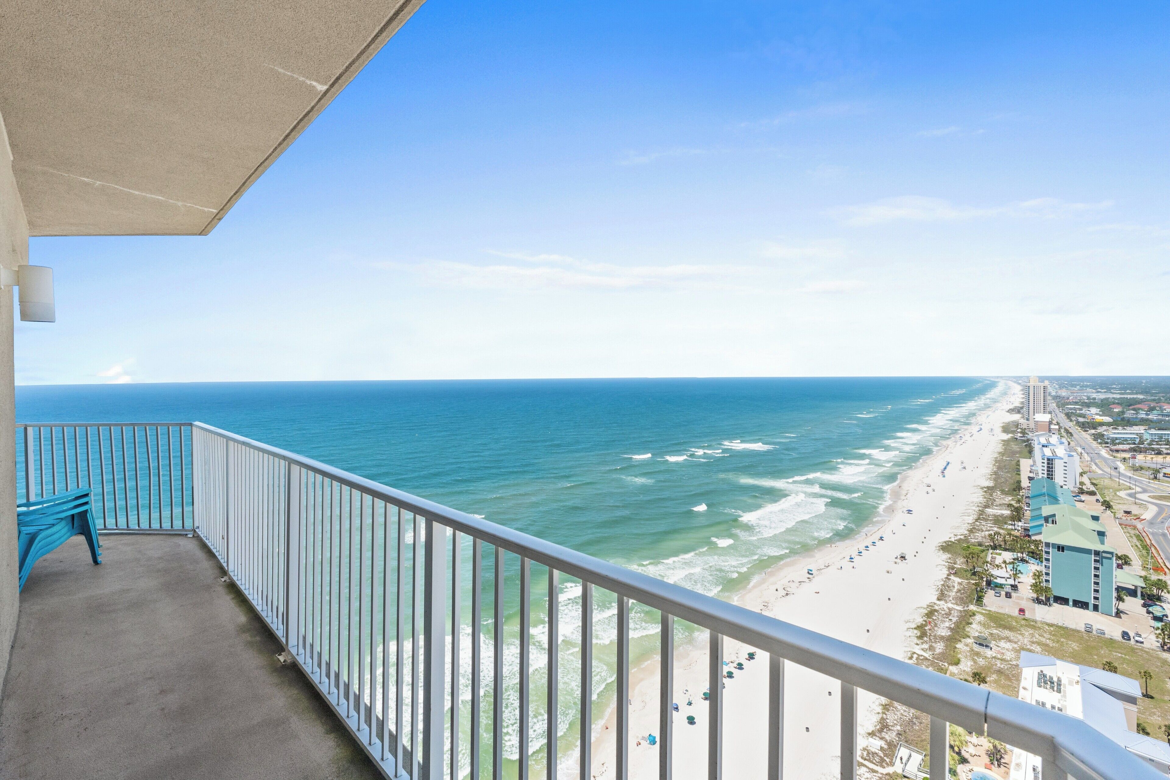 A balcony with a view of the ocean and beach.