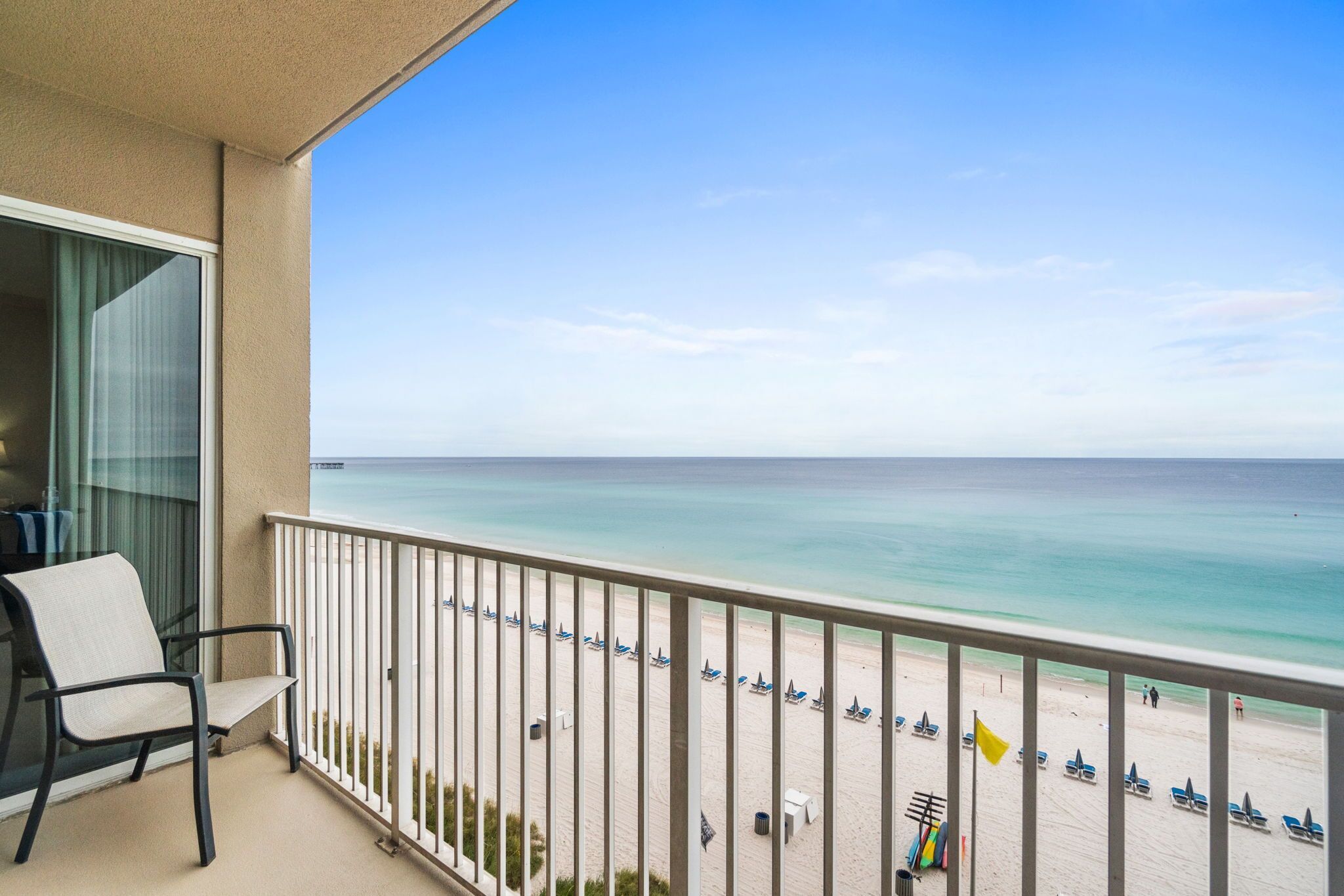 Un balcon avec vue sur une plage et l’océan.