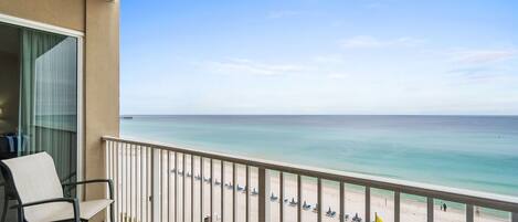 A balcony with a view of a beach and ocean.