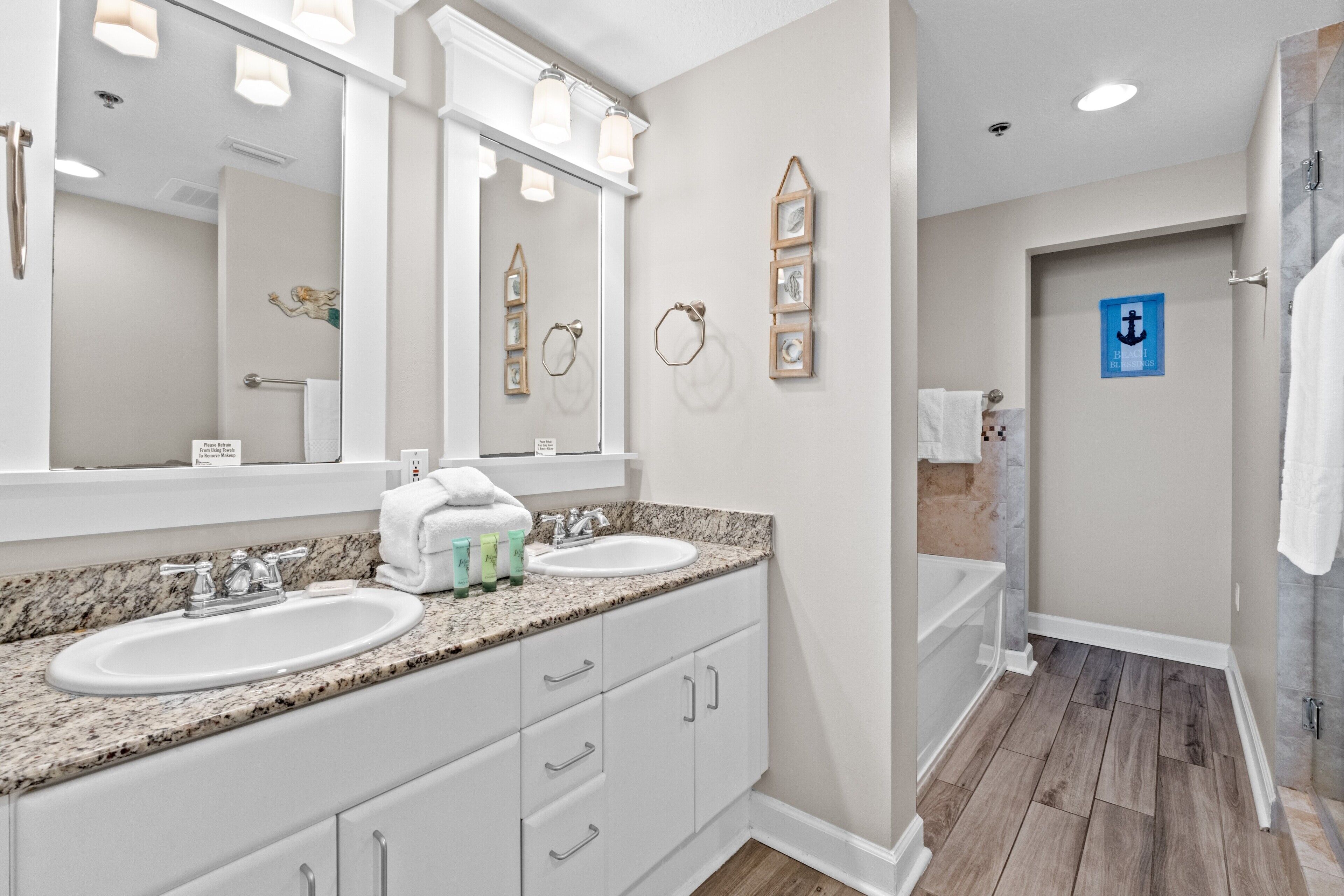 A bathroom with two sinks, a large mirror, and a shower area.