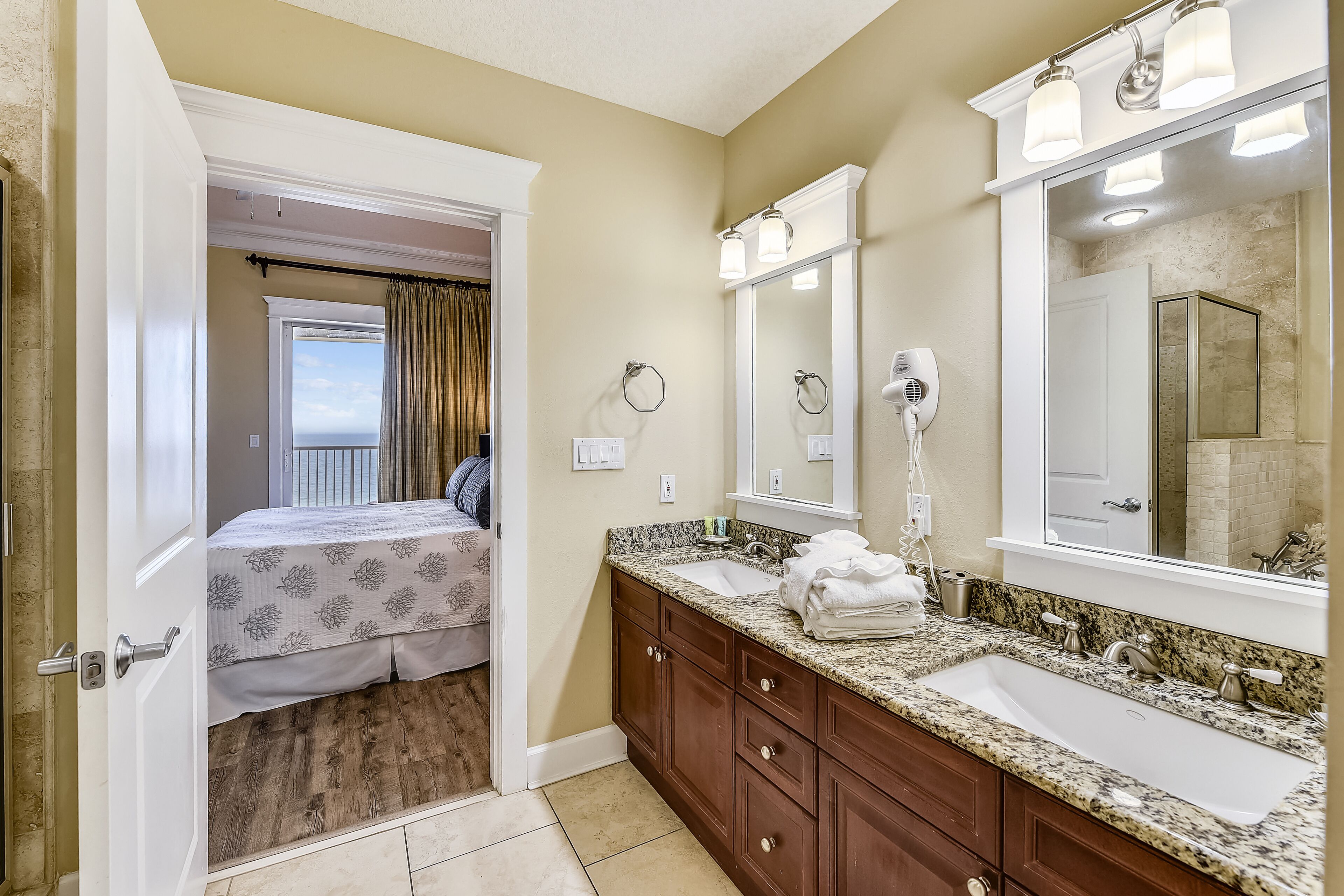 A bathroom with a double sink, vanity, and a large mirror.