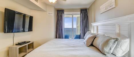 Une chambre à coucher avec un lit, un ventilateur de plafond, une télévision et une vue sur l’extérieur.