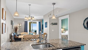 A kitchen with granite countertops, stainless steel appliances, and pendant lighting. - Grand Panama Beach Resort by Book That Condo (Panama City Beach)