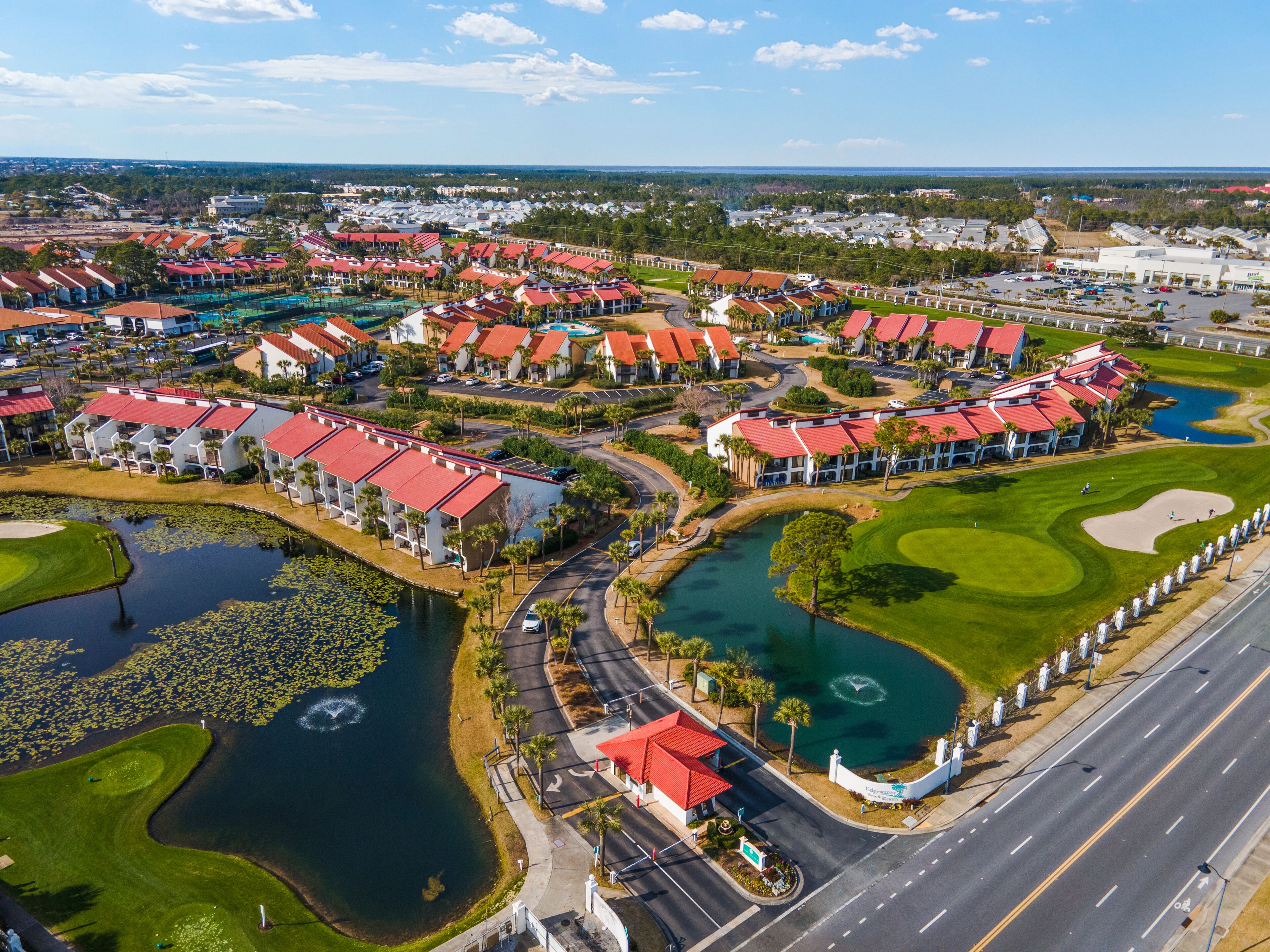 Ein Resort mit mehreren Gebäuden, einem Golfplatz und einem Gewässer.