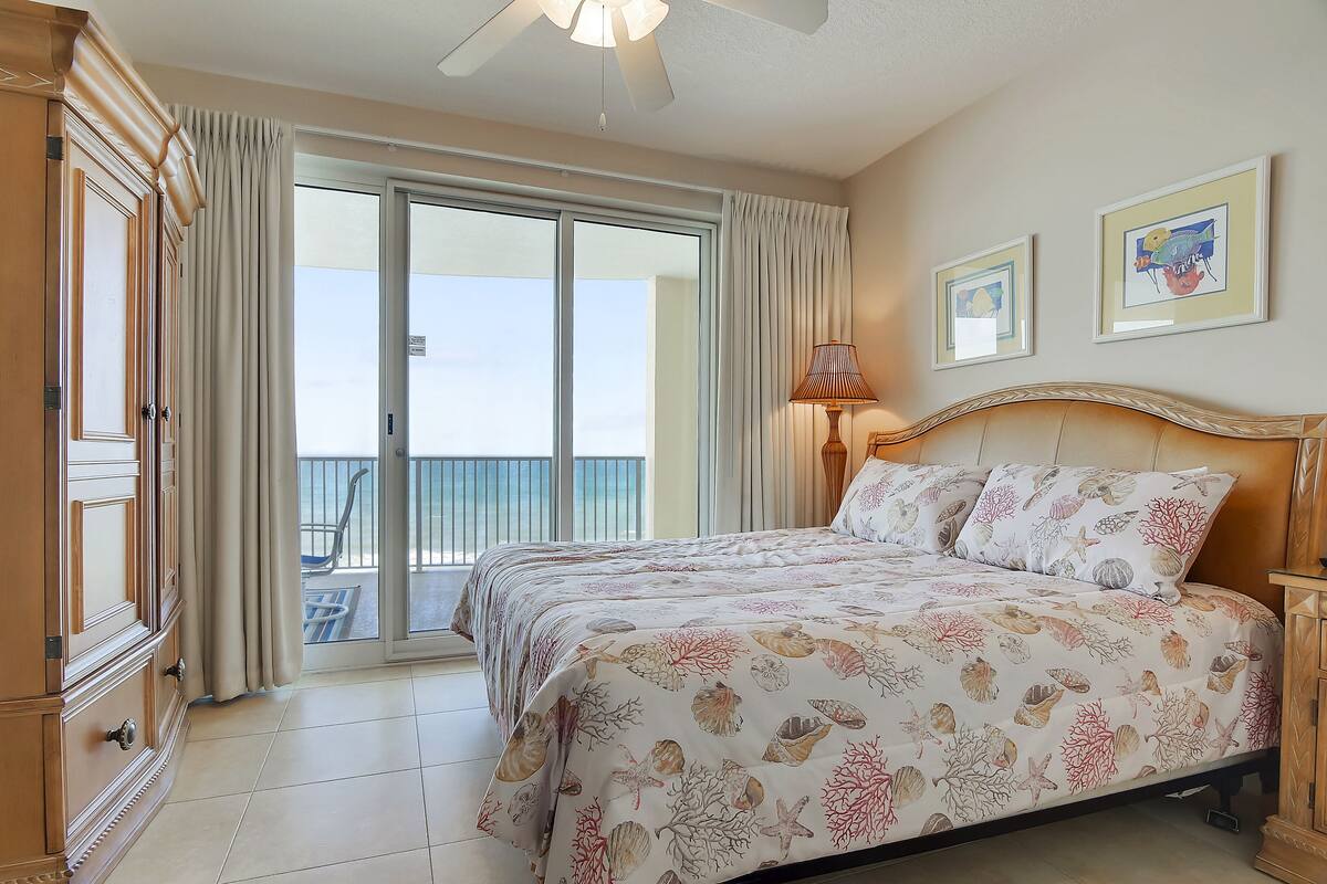 Un dormitorio con cama, balcón y vista al cielo.