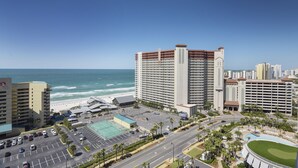 A high-rise hotel with a view of the beach and ocean.