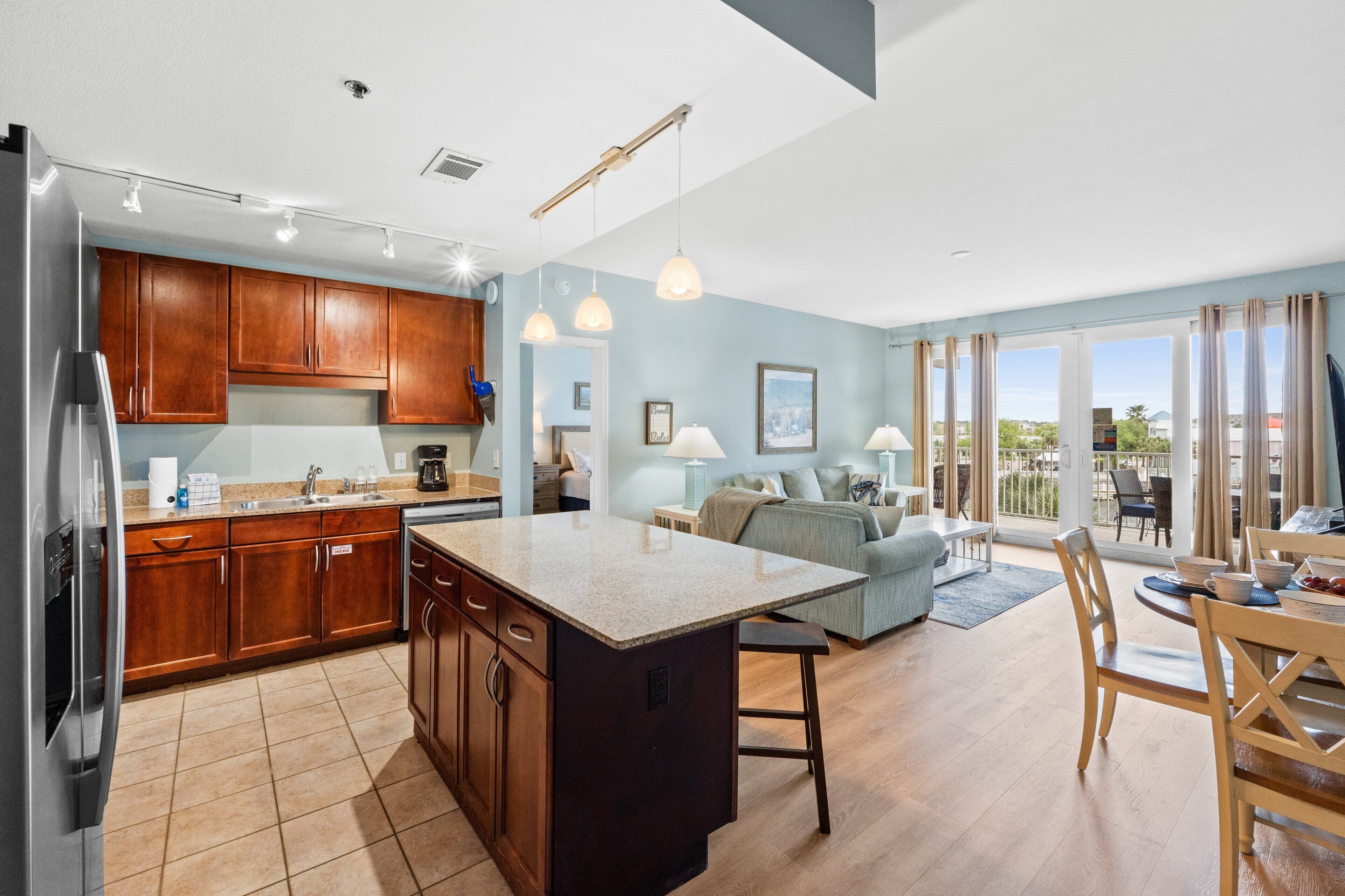 A modern kitchen with wooden cabinets, a central island, and a dining area with a table and chairs.