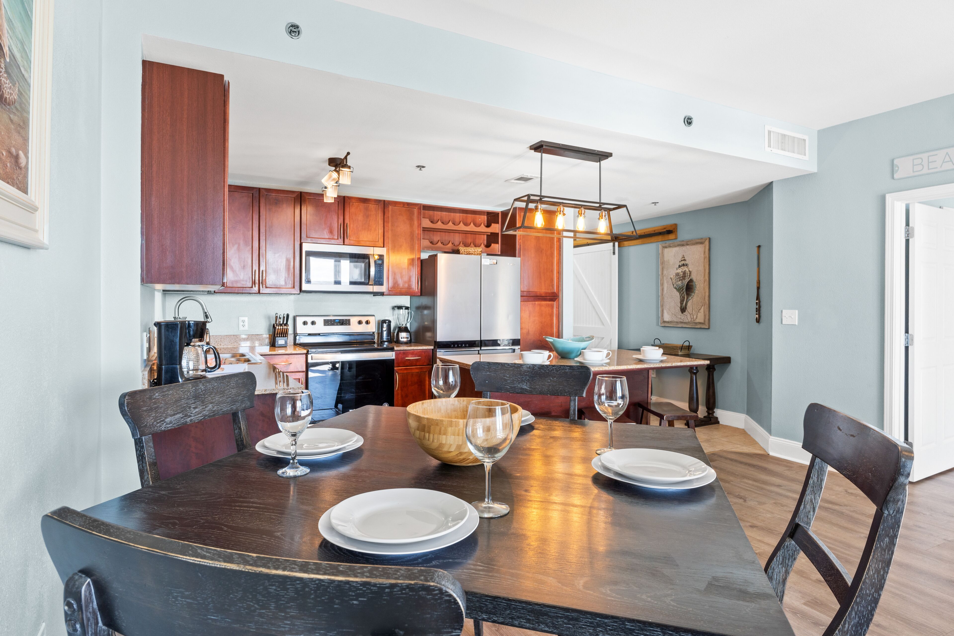 Una cocina moderna con armarios de madera, una mesa de comedor para seis personas y vistas al área de comedor.