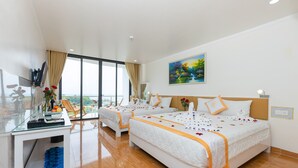 A hotel room with two beds, a glass table with a vase of flowers, a painting on the wall, and a view of the outdoors. - Luxy Park Hotel Phu Quoc Romantic Sunset (Phu Quoc)