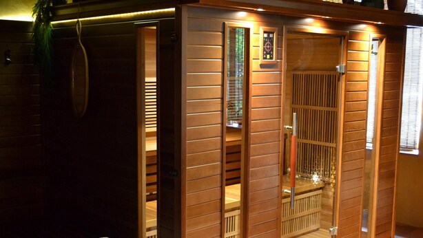 Una sauna con pareti in legno, una panchetta e un asciugamano.